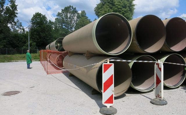 Kar 1200-milimetrske kanalizacijske cevi čakajo, da jih vgradijo v zemljo na Ljubljanskem polju. FOTO: Janez Petkovšek