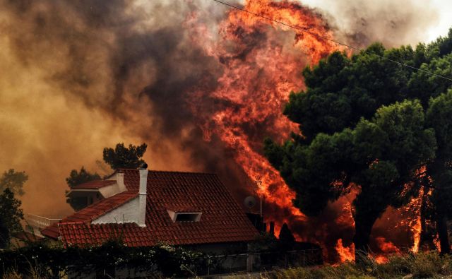 Ogenj je goltal hiše. FOTO: Valerie Gache/AFP