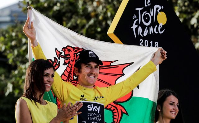 Tour de France 2018 winner Great Britain&#39;s Geraint Thomas (C) holds a Welsh flag as he celebrates his overall leader yellow jersey on the podium after the 21st and last stage of the 105th edition of the Tour de France cycling race between Houilles and Paris Champs-Elysees, on July 29, 2018. / AFP PHOTO / Thomas SAMSON Foto Thomas Samson Afp