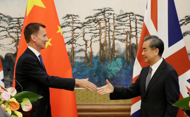 Kitajski zunanji minister Wang Yi si ni vzel k srcu prvega spodrsljaja britanskega zunanjega ministra Jeremyja Hunta (levo). FOTO: Reuters