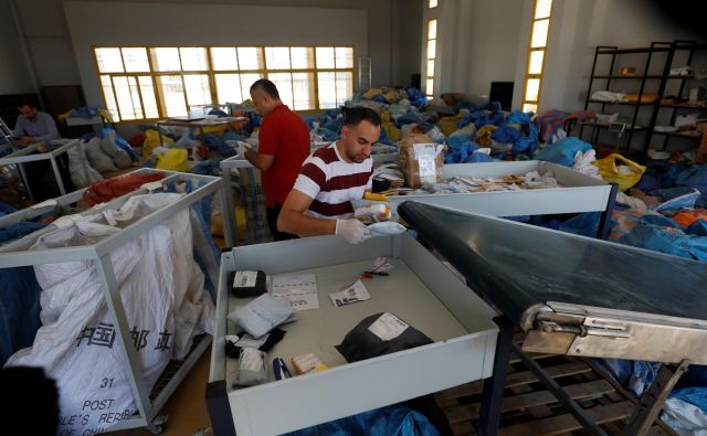 Zaposleni na pošti so v zadnjih dneh kupe pisem in paketov razvrščali v mestu Jeriho na Zahodnem bregu. FOTO: Mohamad Torokman/Reuters