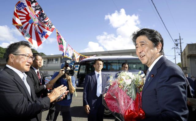 Japonski premier Šinzo Abe je dobil šopek cvetja, ko je sporočil, da bo še tretjič kandidiral za predsednika vladajoče Liberalnodemokratske stranke. FOTO: Reuters