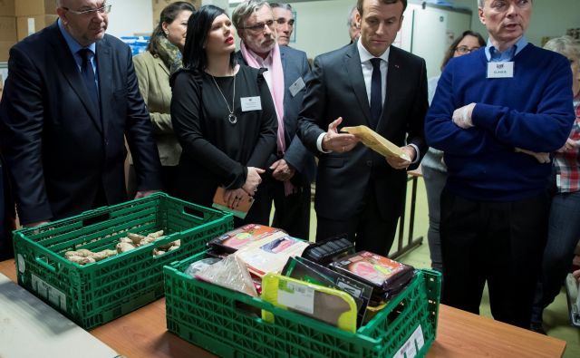 Predsednik Emmanuel Macron v človekljubni razdelilnici hrane Les Restos du Coeur. FOTO: Reuters