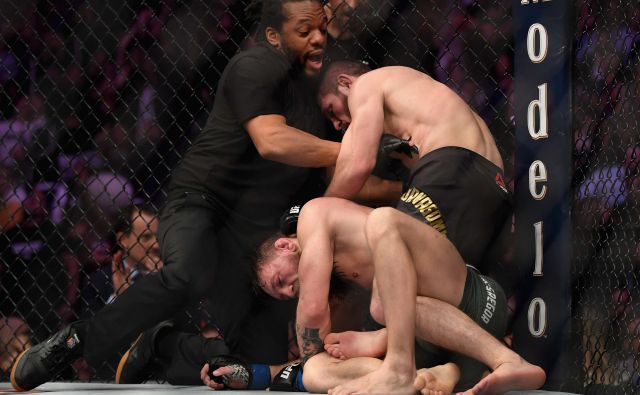 Habib Nurmagomedov (zgoraj) je z davljenjem v četrti rundi prisilil k vdaji Conorja McGregorja. FOTO: AFP