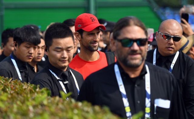 Novak Đoković (v Šanghaju na poti na trening ob številnih varnostnikih) je nared za zmagoviti finiš sezone. Foto: AFP