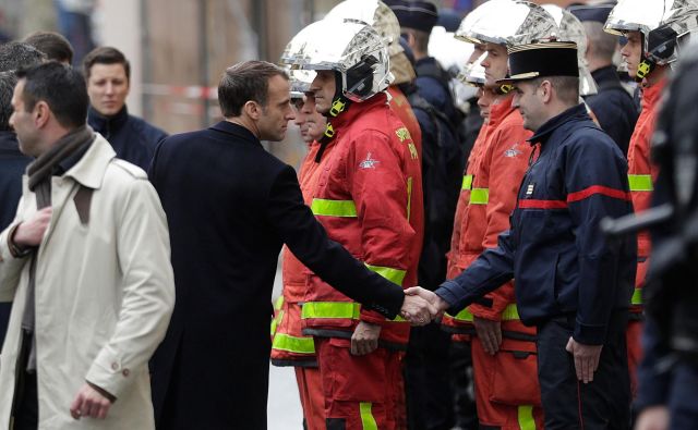 Francoski predsednik pozdravlja pripadnike gasilskih enot, ki so posredovali pri gašenju požarov na desetine požarov v središču Pariza. FOTO: Geoffroy VAN DER HASSELT / AFP