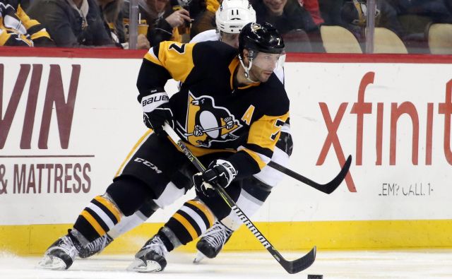 Pittsburghov hokejist Matt Cullen vodi plošček pred Anžetom Kopitarjem (v ozadju). FOTO: Usa Today Sports