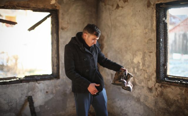 Alžirec Abdul Mamun v svoji sobi, ki je pred kratkim pogorela. Edino, kar je 22-letniku ostalo, so pohodni čevlji. Možnosti, da ga bodo ponesli v obljubljeno deželo Evropo, je vse manj. FOTO: Jure Eržen/Delo