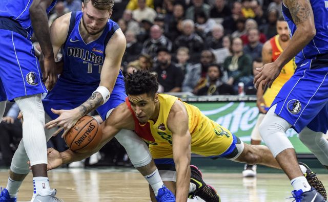 Luka Doncic se je takole boril za žogo z Malcolmom Brogdonom. FOTO: Reuters