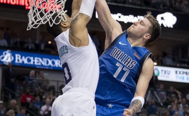 Luki Dončiću ni šlo vse kot po maslu, a je vseeno tekmo zaznamoval z novim trojnim dvojčkom. Takole ga je pri poskusu ”zabijanja” z blokado ustavil branilec moštva Charlotte Miles Bridges. FOTO: Usa Today Sports