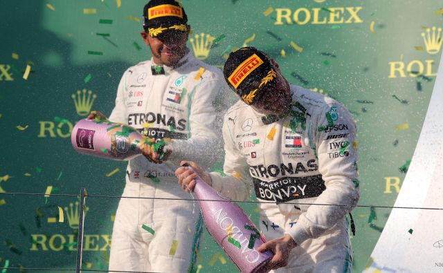 Če že ni mogel prehiteti moštvenega tekmeca Valtterija Bottasa, si je Lewis Hamilton (levo) dal duška pri špricanju šampanjca. FOTO: AFP