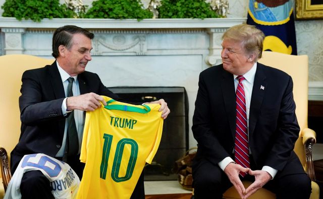 Brazilski predsednik Jair Bolsonaro in njegov ameriški kolega Donald Trump sta včerajšnji obisk ozaljšala z izmenjavo nogometnih majic. Trump je dobil Peléjevo desetico. FOTO: Reuters