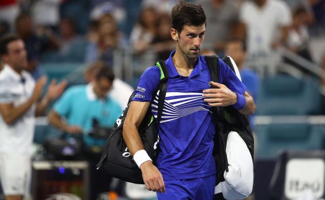 Novak Đoković je z igrišča odkorakal sklonjene glave. FOTO: Julian Finney/AFP