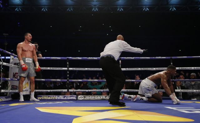 Ukrajinski boksarski šampion Vladimir Kličko (levo) je takole pred dvema letoma v šesti rundi poslal na tla britanskega zvezdnika Anthonyja Joshuo. FOTO: Reuters