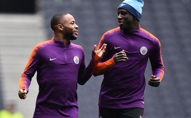 Raheem Sterling (levo) in Benjamin Mendy sta kramljala med sinočnjim treningom Manchester Cityja. FOTO: AFP