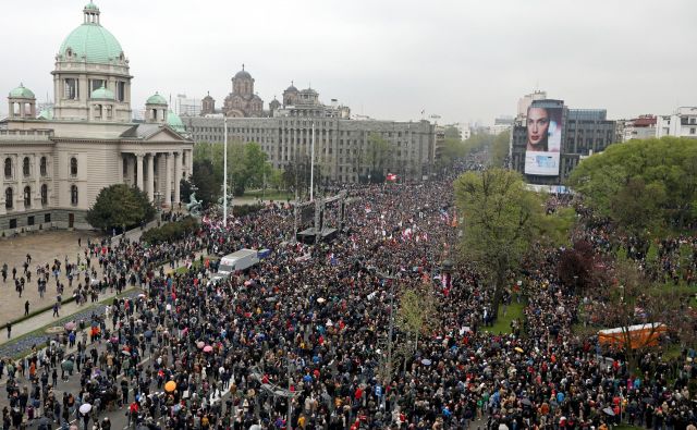 Protest poteka mirno, množica skandira proti predsedniku, ljudje žvižgajo in bobnajo. FOTO: Djordje Kojadinović/Reuters