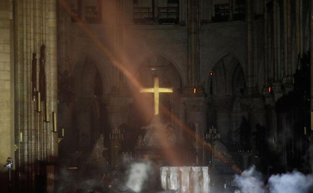 Križ nad oltarjem še vedno stoji in oddaja zlati sijaj. FOTO: Philippe Wojazer/Reuters