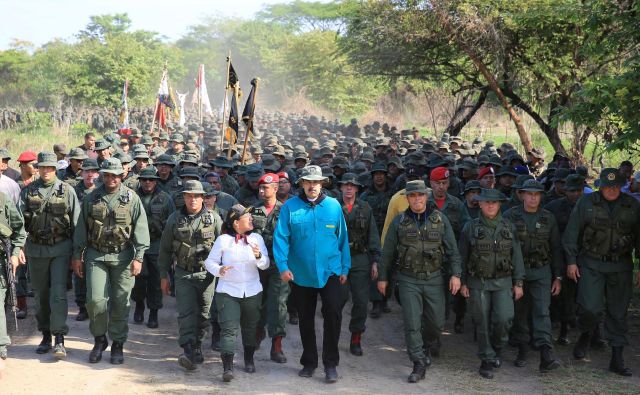 Venezuelski predsednik Maduro hodi ob boku obrambnega ministra in predstavnikov vojske med njegovim obiskom vojaškega oporišča v El Pau. FOTO: Reuters