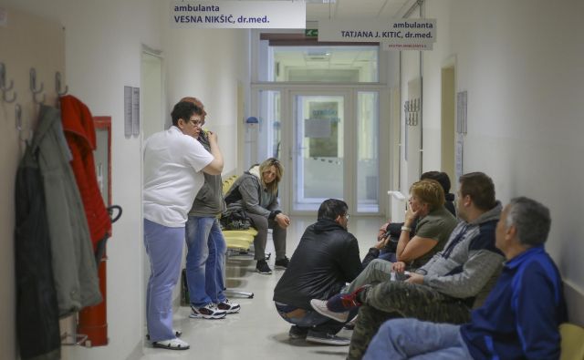 Včeraj je bil hodnik pred ambulantami družinske medicine poln, pacienti so sprijaznjeno čakali, vprašanje je, kako dolgo še. FOTO: Jože Suhadolnik