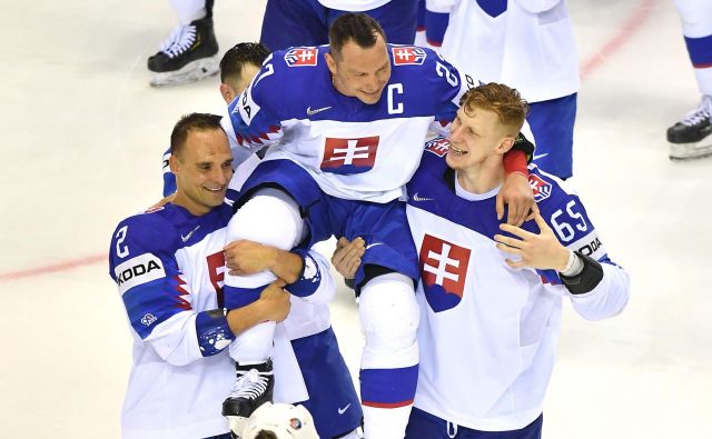 Po zadnji tekmi sta takole Ladislava Nagya z ledu odnesla Andrej Sekera (levo) in Michal Čajkovsky. FOTO AFP