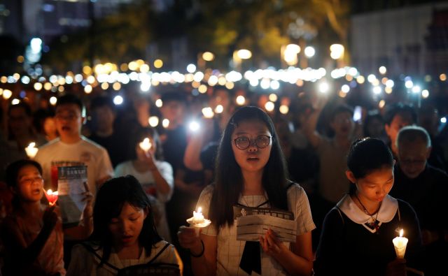 Po podatkih organizatorjev se je jubilejne večerne komemoracije v parku Victoria v Hongkongu udeležilo 180.000 ljudi. FOTO: Tyrone Siu/Reuters