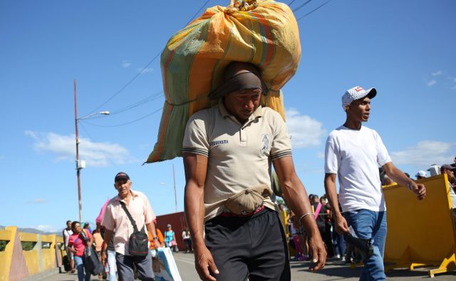 Prebežniki, ki prečajo kolumbijsko-venezuelsko mejo. FOTO: Carlos Eduardo Ramirez/Reuters