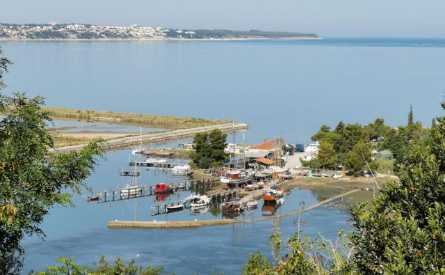 Pogled na ustje Jernejevega kanala, ki kar kliče po ureditvi. V ospredju je škver s starimi lesenjačami, za njim pa je skrit ribiški pristan. Foto Boris Šuligoj