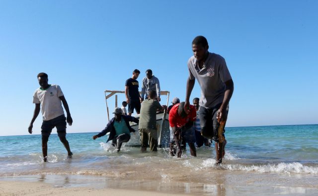 Rešeni migranti na obali Tripolija. FOTO: Ismail Zitouny/Reuters