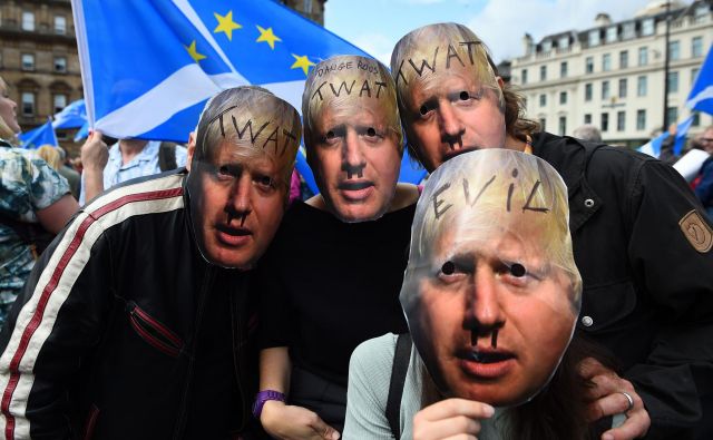 Protestniki z maskami Borisa Johnsona. FOTO: Andy Buchanan/AFP