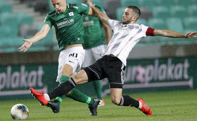 Ljubljančani so po hudem boju z desetimi igralci, potem ko je bil v 78. minuti izključen Tomislav Tomić (levo), le prišli do pete prvenstvene zmage. Kapetan Mure Alen Kozar (desno) pa je prvič v sezoni okusil grenkobo poraza. FOTO: Mavric Pivk/Delo