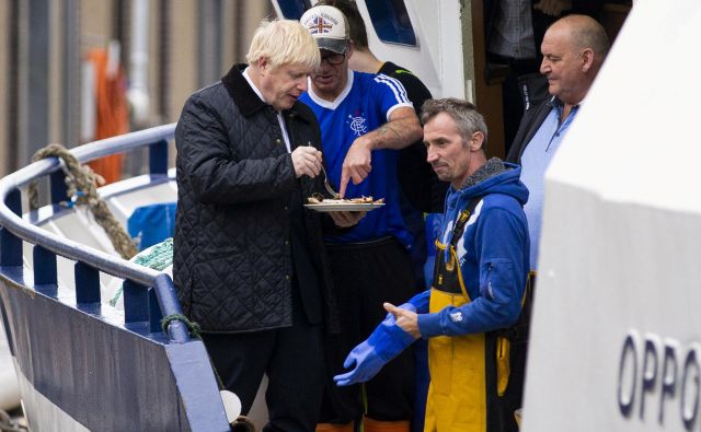 Boris Johnson se je med današnjim obiskom na Škotskem družil tudi s tamkajšnjimi ribiči, ki načeloma veljajo za najbolj zagrete zagovornike brexita. Foto Reuters