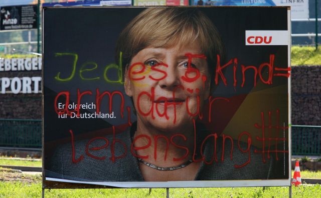 »Vsak peti otrok je reven, zato dosmrtni zapor.« Grafit med volilno kampanjo Angele Merkel. FOTO: Matthias Schumann/Reuters