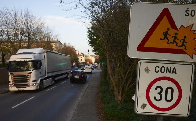 Po Cesti v Mestni log, kjer je tudi šolska pot, vsak dan pelje več deset težkih vlačilcev, ki bi lahko do industrijske cone pripeljali neposredno z obvoznice, če bi MOL in Dars na Viču zgradila dodatni priključek na avtocesto. FOTO: Primož Zrnec/Delo