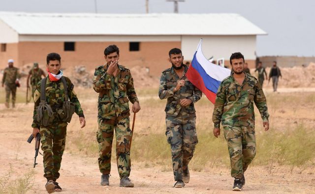 Pripadniki sirskih vladnih sil z rusko zastavo. Foto: AFP