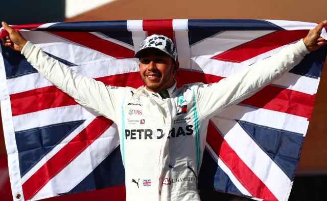 Lewis Hamilton se je z britansko zastavo veselil šestega naslova svetovnega prvaka. FOTO: AFP