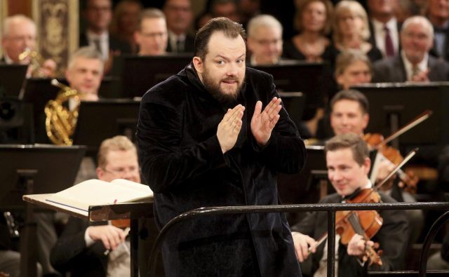 Latvijski dirigent Andris Nelsons med dirigiranjem novoletnega koncerta. FOTO: Ronald Zak/Ap