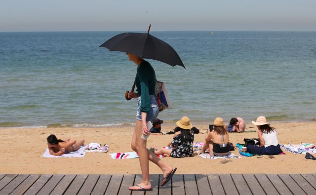 Na plaži na včerajšnji rekordno vroč dan v avstralski zvezni državi Viktoriji. FOTO: Stringer via Reuters