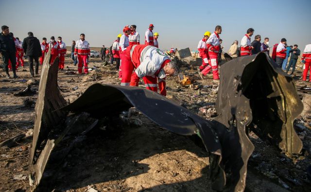 Predstavniki Rdečega križa preiskujejo ostanke ukrajinskega potniškega letala, ki je strmoglavilo v bližini Teherana. FOTO: Reuters