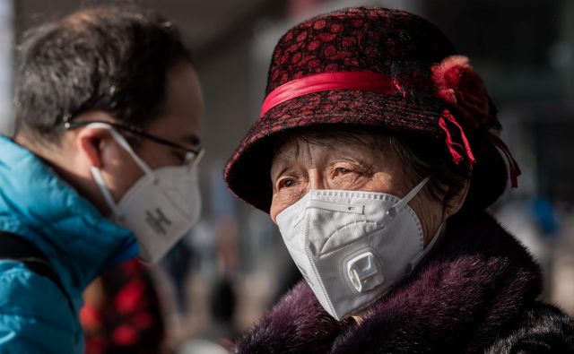 Kitajci so že pred dnevi potrdili, da se virus prenaša med ljudmi, a glavni izvor izbruha so domnevno živali. Za izhodišče virusa trenutno opredeljujejo veletržnico z živimi ribami in drugimi živalmi v Wuhanu. FOTO: Nicolas Asfouri/AFP