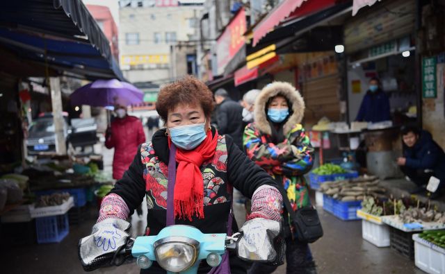 V Wuhanu se je zbrala smetana visokih in novih tehnologij ter njihove podružnice, ki se ponašajo s predpono bio-, zato ni naključje, da se širijo govorice, da je virus ušel iz enega od tamkajšnjih laboratorijev. Na fotografiji prebivalka med vožnjo skozi mestno tržnico. FOTO: AFP