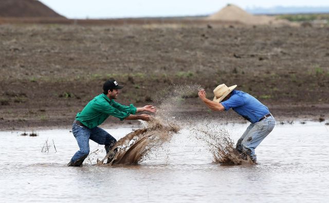 Soseda s kmetij v Liverpool Plains v Novem južnem Walesu James Purshouse (levo) in Jock Tudgey se veselita obilnega dežja, ki je končal triletno sušo in omejil nekaj mesecev trajajoče požare. FOTO: Stringer/Reuters