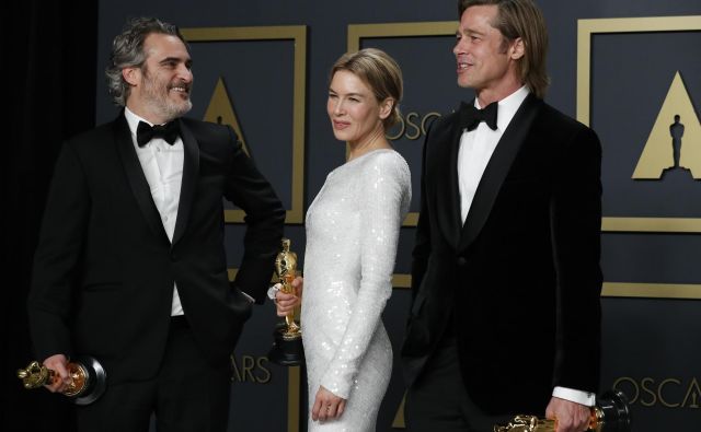 Joaquin Phoenix, Renee Zellweger in Brad Pitt pozirajo z zlatimi kipci. FOTO: Lucas Jackson/Reuters