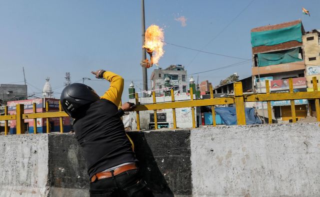 Podpornik Modijeve skrajne hindujske stranke meče bencinsko bombo na muslimansko svetišče. FOTO: Danish Siddiqui/Reuters