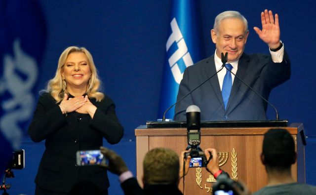 Izraelski premier Benjamin Netanjahu z ženo Saro pozdravlja svoje podpornike. FOTO: Gil Cohen-Magen/AFP