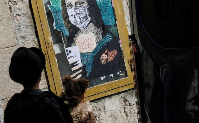 Prizor z ulic Barcelone: otrok in Mona Liza z zaščitno masko. FOTO: Nacho Doce/Reuters