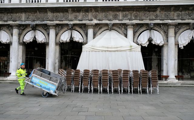 Še pred dnevi so stoli pred restavracijo na osrednjem beneškem trgu čakali na goste, včeraj jih niti razpostavili niso več. FOTO: Reuters