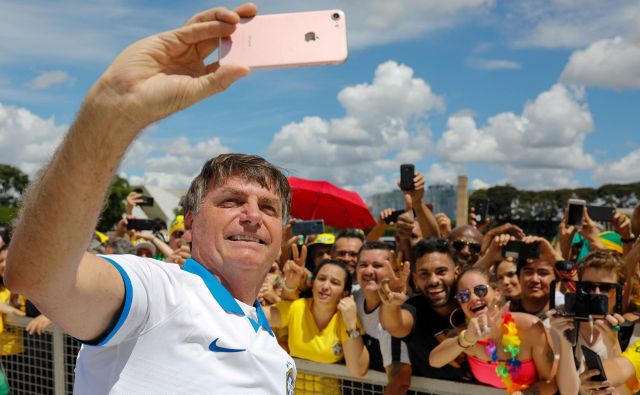 Brazilski predsednik Jair Bolsonaro se je včeraj družil s svojimi podporniki. FOTO: Sergio Lima/AFP