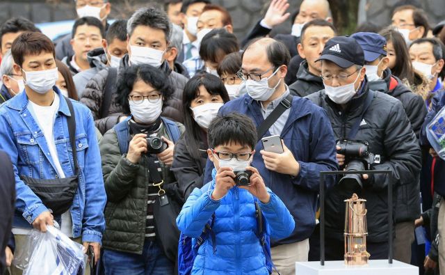 Japonci se še vedno zgrinjajo v dolgih vrstah, da bi od blizu videli olimpijski ogenj. FOTO: Reuters