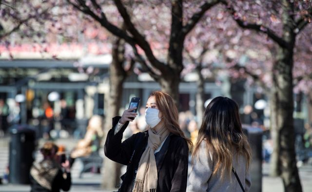 Za Japonce je čustvena vez s češnjevim cvetom preveč pomembna, da bi se odrekli hanamiju. FOTO: Reuters