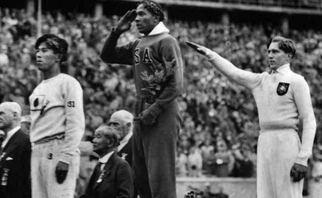 Jesse Owens (v sredini) po olimpijski zmagi v skoku v daljavo, desno srebrni Nemec Luz Long. FOTO: Arhiv MOK